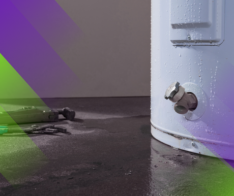 Leaking water heater on dark floor, with water spilling around the base.