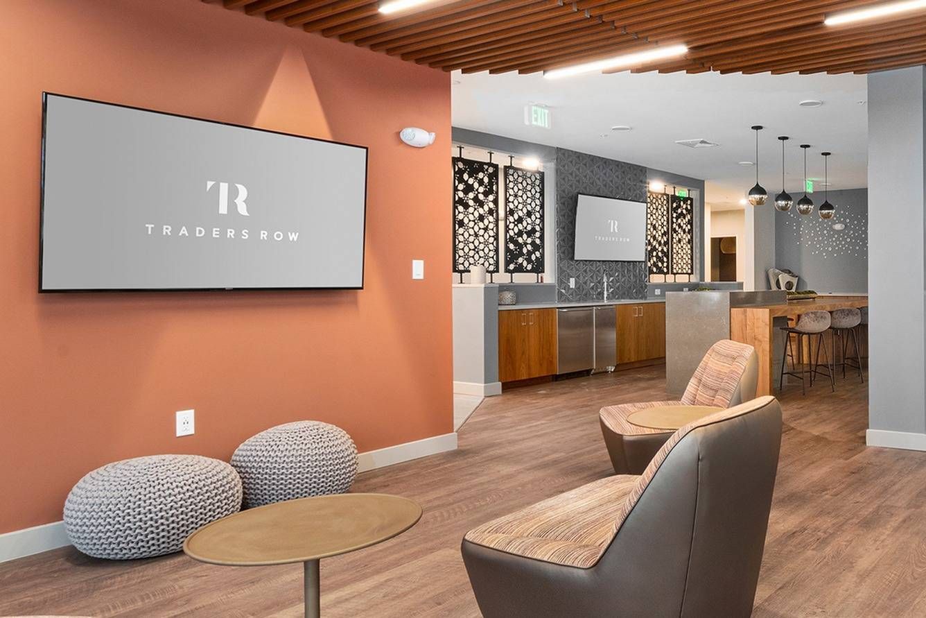 Traders Row entertainment lounge with TV and seating area. 