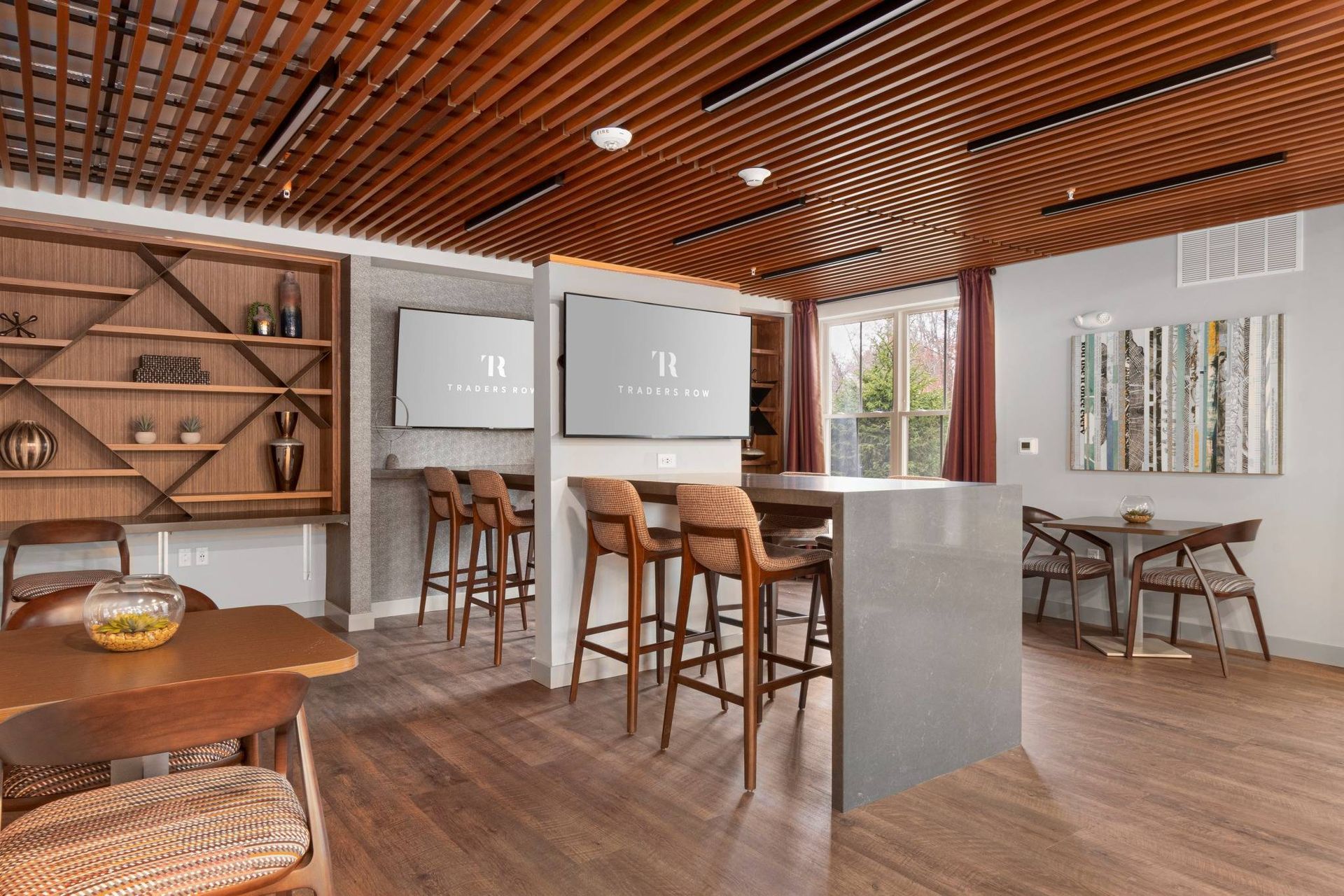 Traders Row modern clubhouse with bar seating and TVs. 
