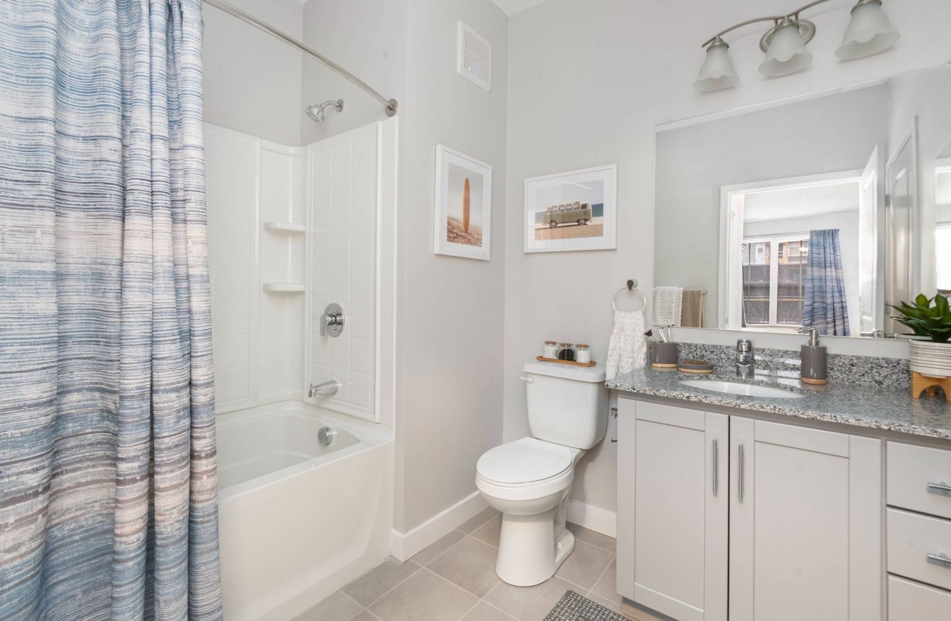 Resort-style bathroom with shower/bath, toilet, sink, and mirror at Traders Row.
