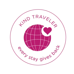 Pink circular Kind Traveler logo with globe and heart, text “every stay gives back”