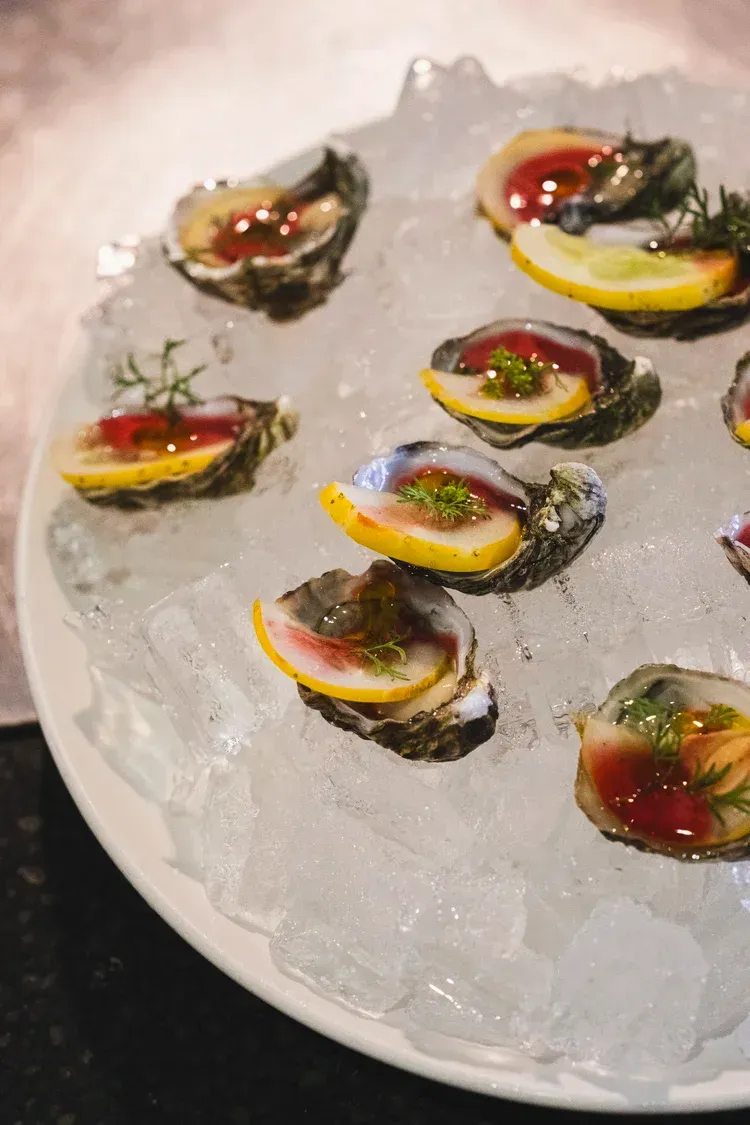 Assorted colorful sushi bites arranged on a bed of crushed ice on a plate