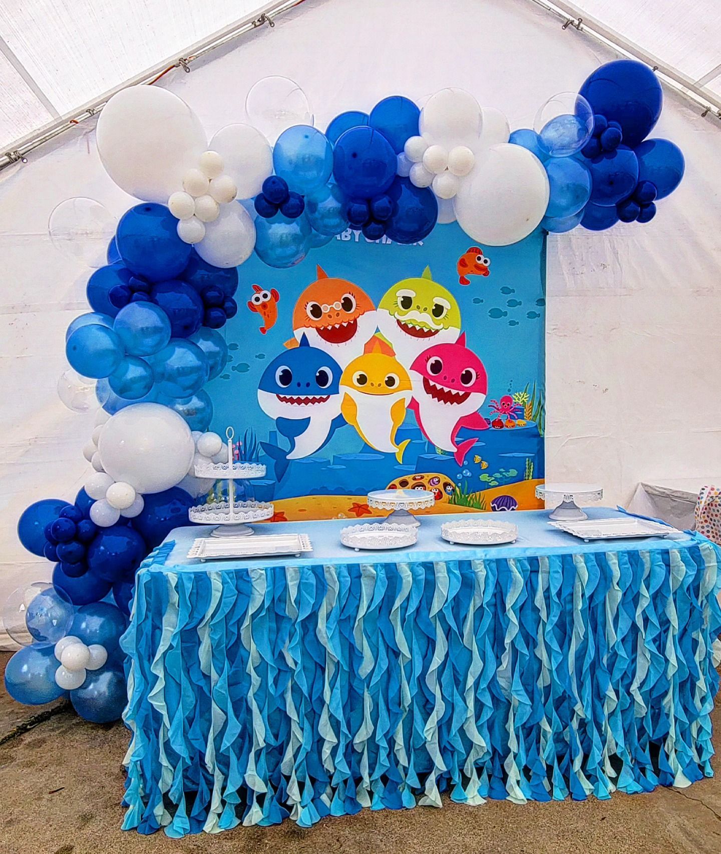 Blue-and-white baby shark party table with matching balloon arch and backdrop