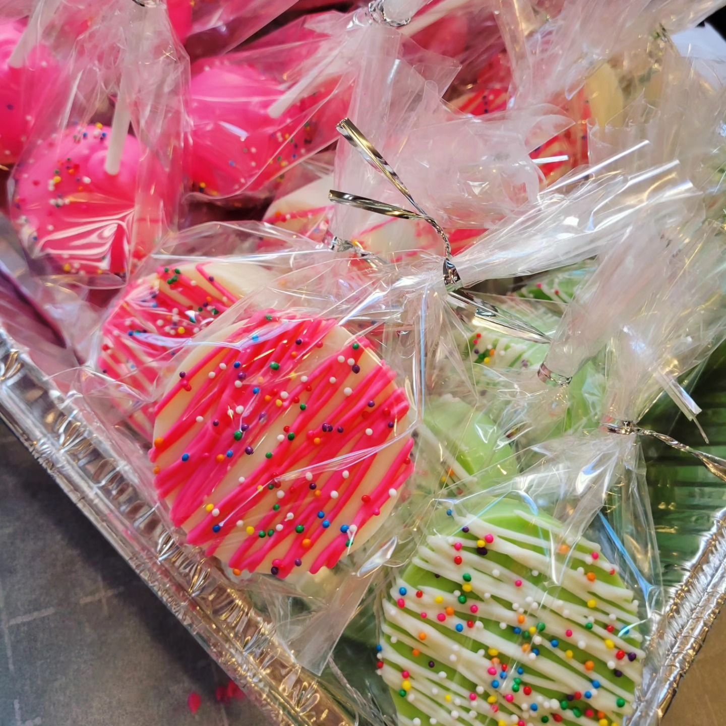 Assorted colorful striped heart-shaped cookies wrapped in clear plastic trays