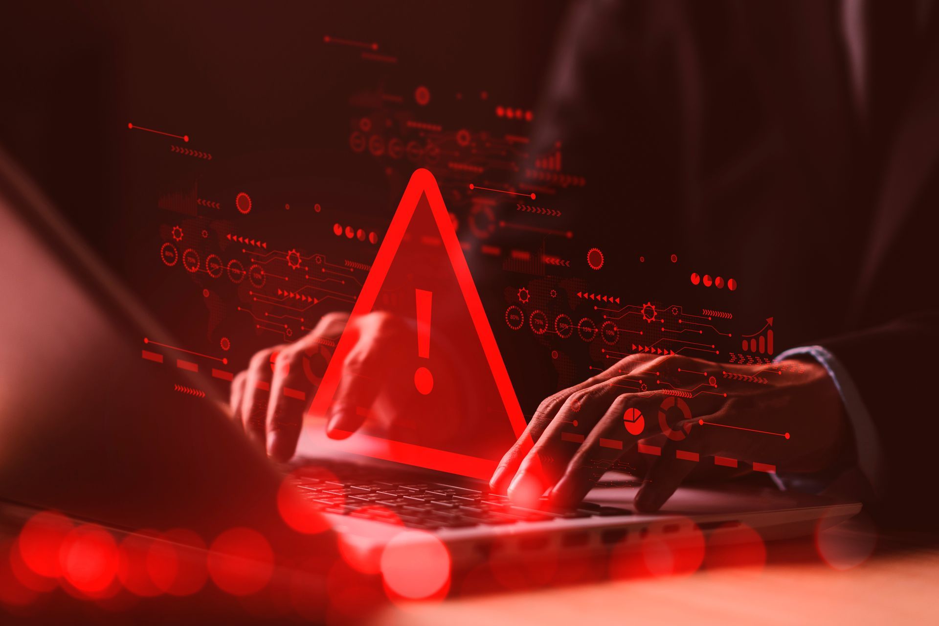 Person typing on laptop, overlaid with a red warning triangle and digital data.