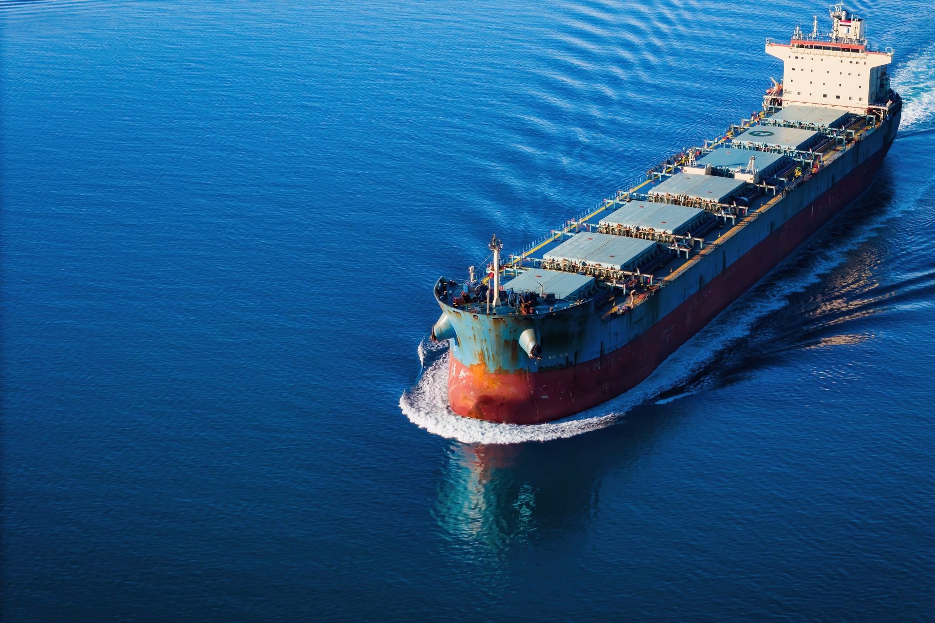 Large cargo ship sailing on blue water.