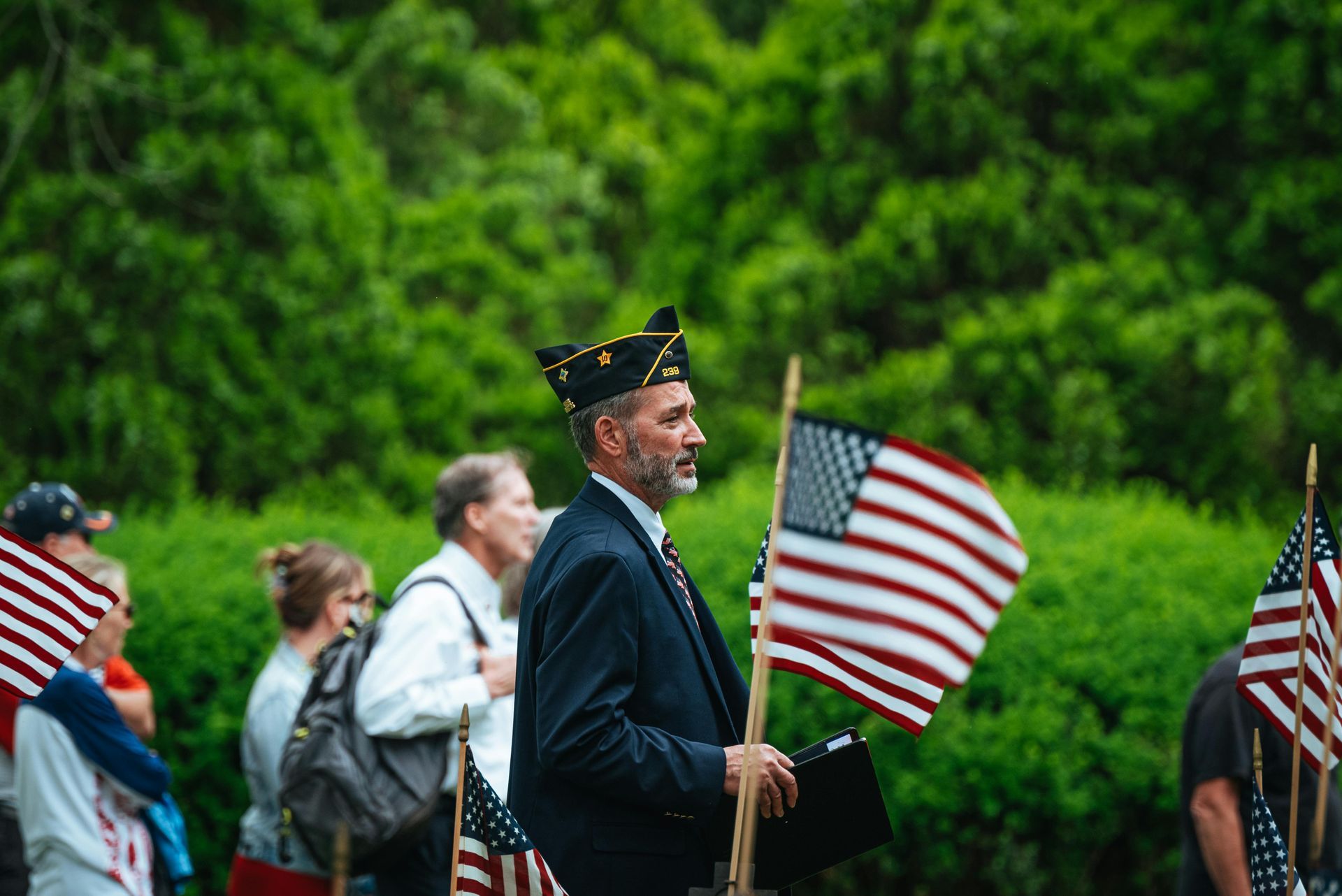Veteran marching with American flags at a memorial parade outdoors