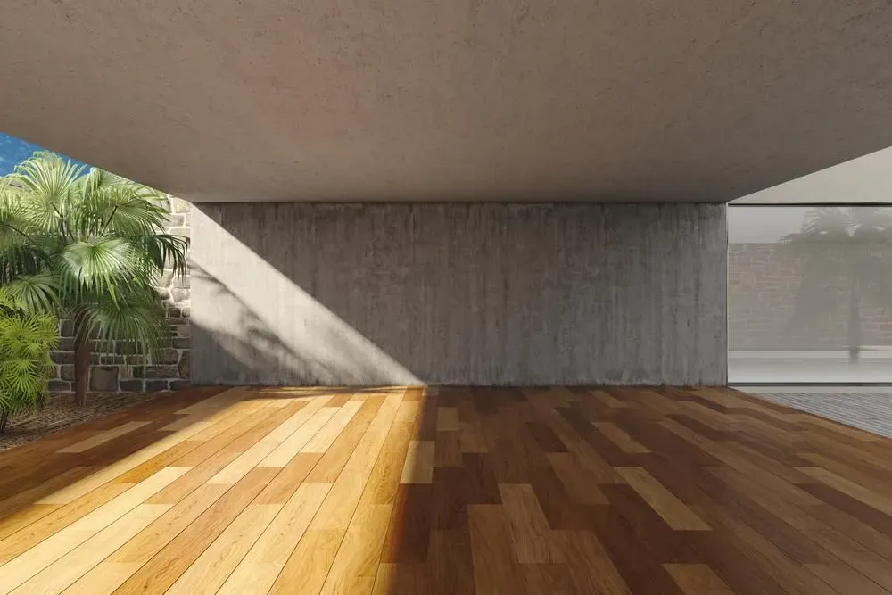An Empty Room With a Wooden Floor and a Concrete Wall — Alan Aldridge Floor Sanding in Hervey Bay, QLD