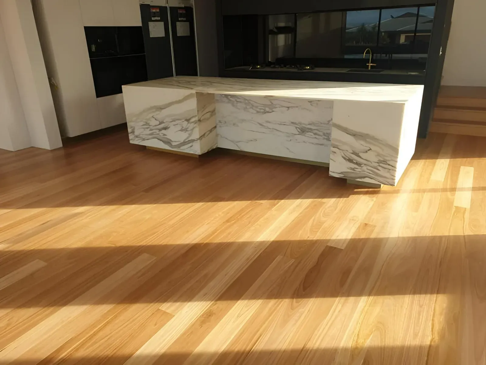 A Kitchen With a Wooden Floor and a Marble Counter Top — Alan Aldridge Floor Sanding in Urraween, QLD