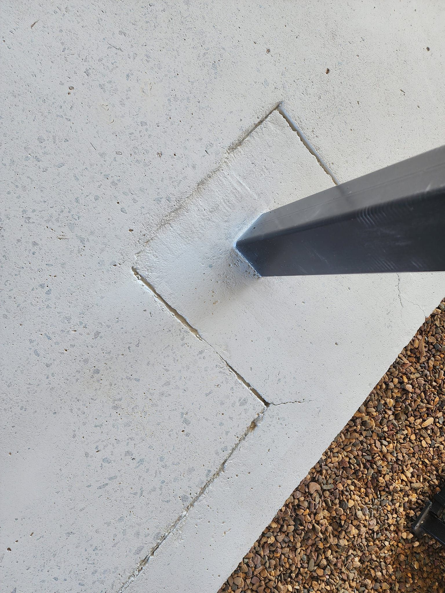 Concrete surface with dark metal pole, cracked square cut around the pole base — Alan Aldridge Floor Sanding in Urraween, QLD