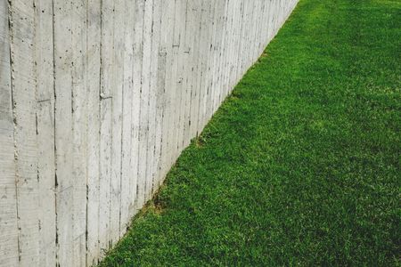 Concrete wall bordering a green grass slope