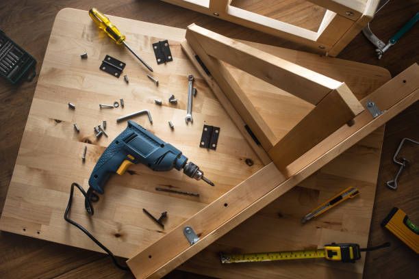 Drill and tools on a wooden surface, assembling a wooden frame.
