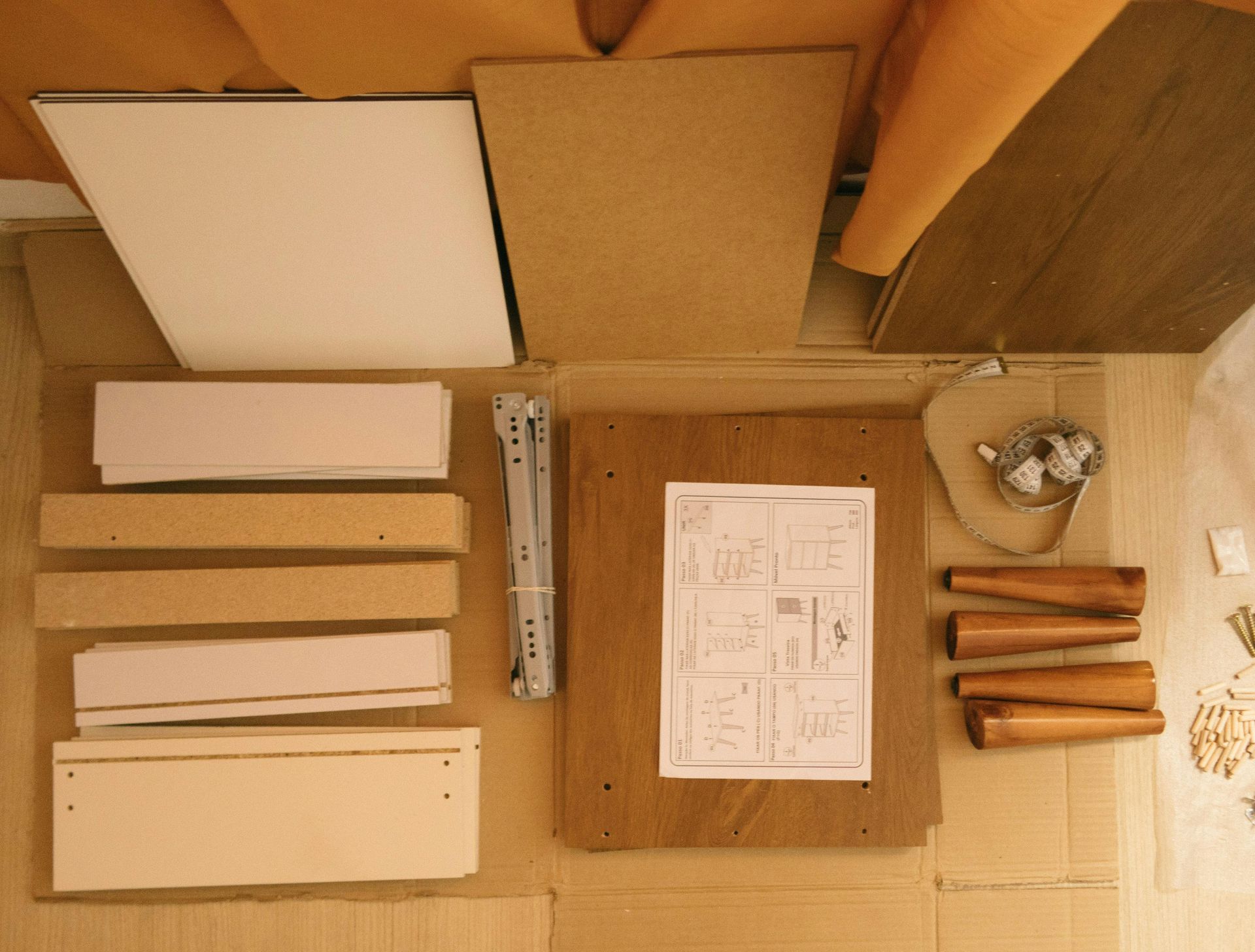 Top-down view of wooden craft materials, templates, ruler, and small wooden parts arranged on a worktable