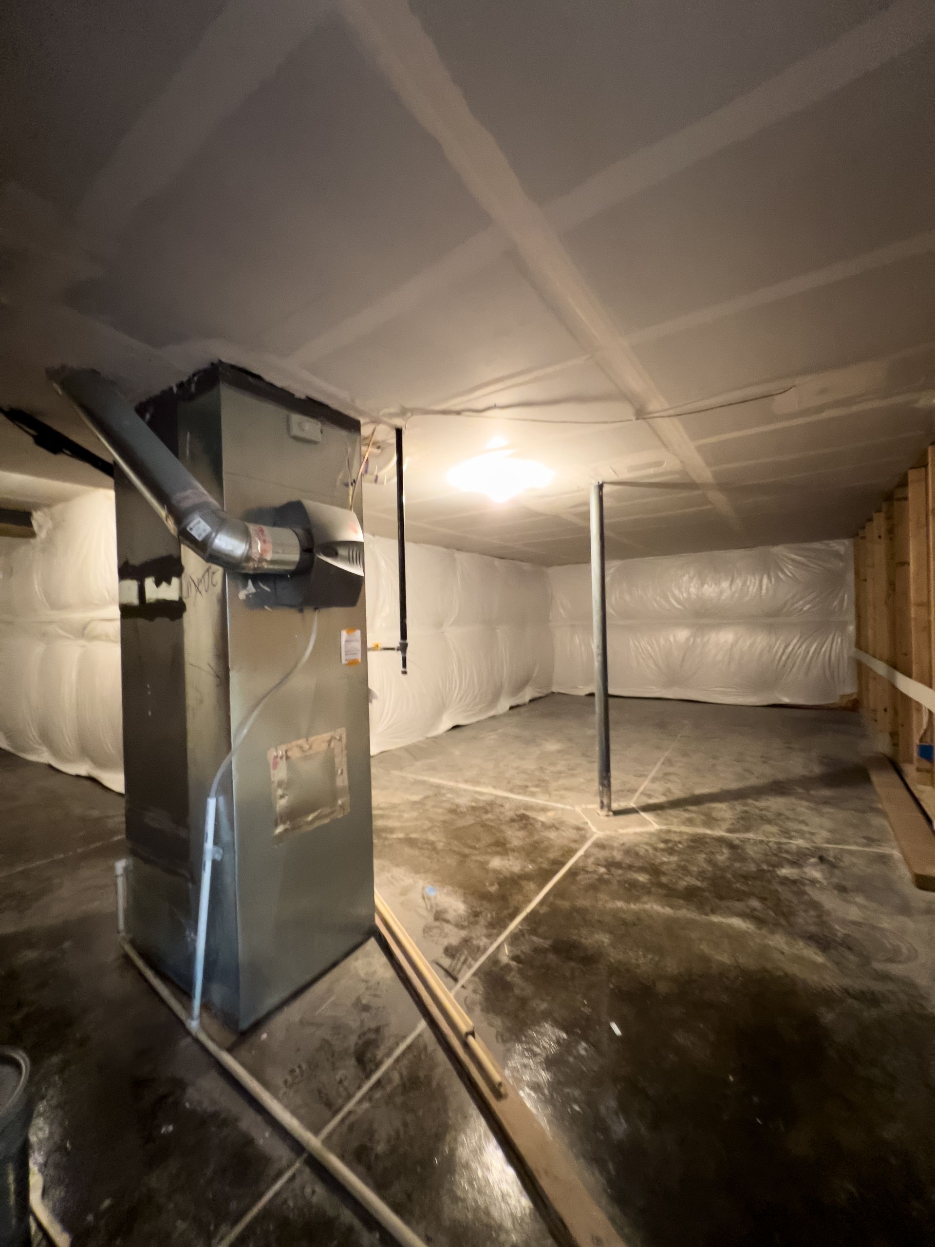 Basement utility room with HVAC unit, ductwork, pipes, and concrete floor.