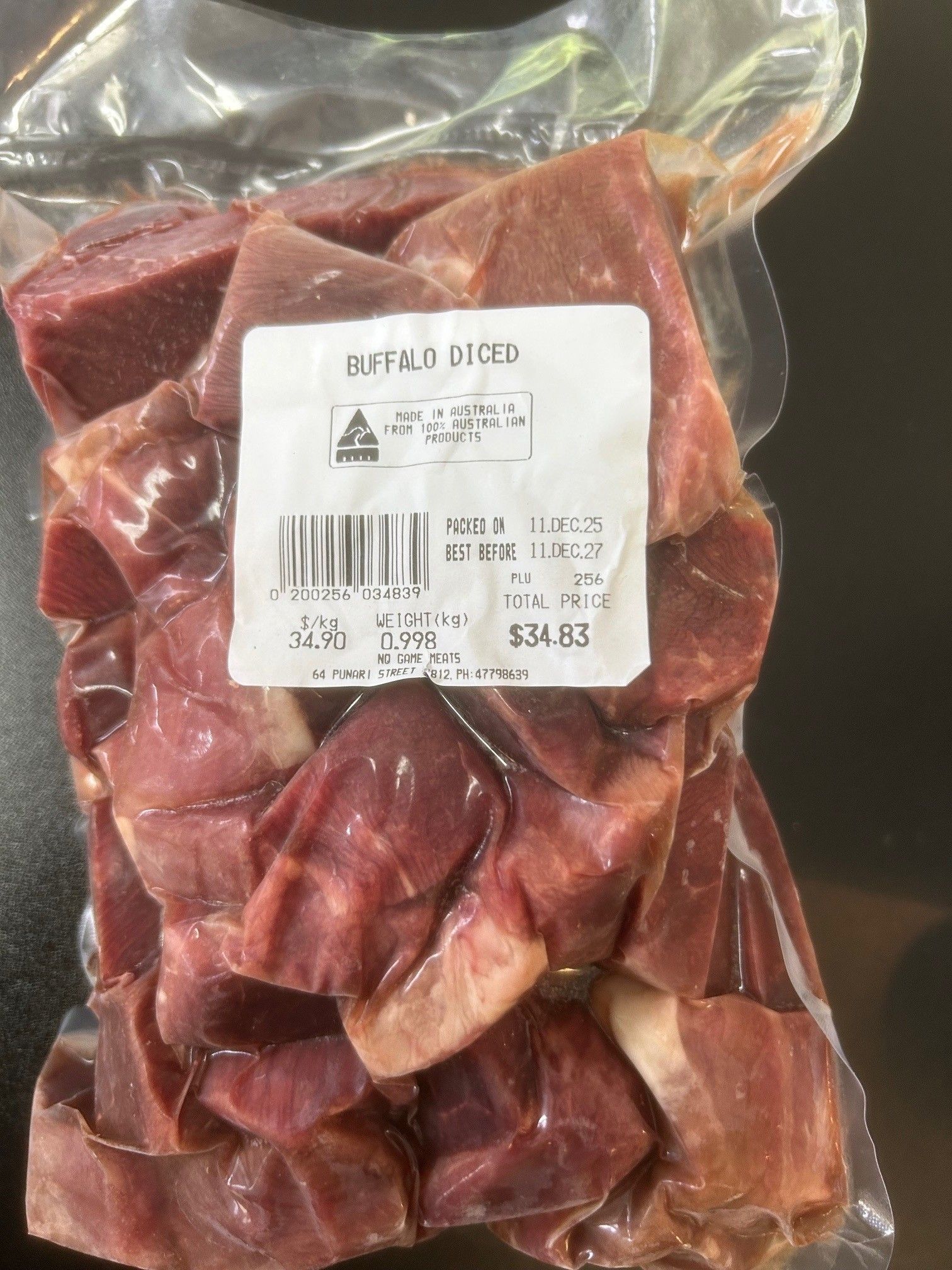Bag of diced buffalo meat, vacuum-sealed with a label. The meat is red and the label is white with black text — NQ GAME MEAT in Currajong, QLD