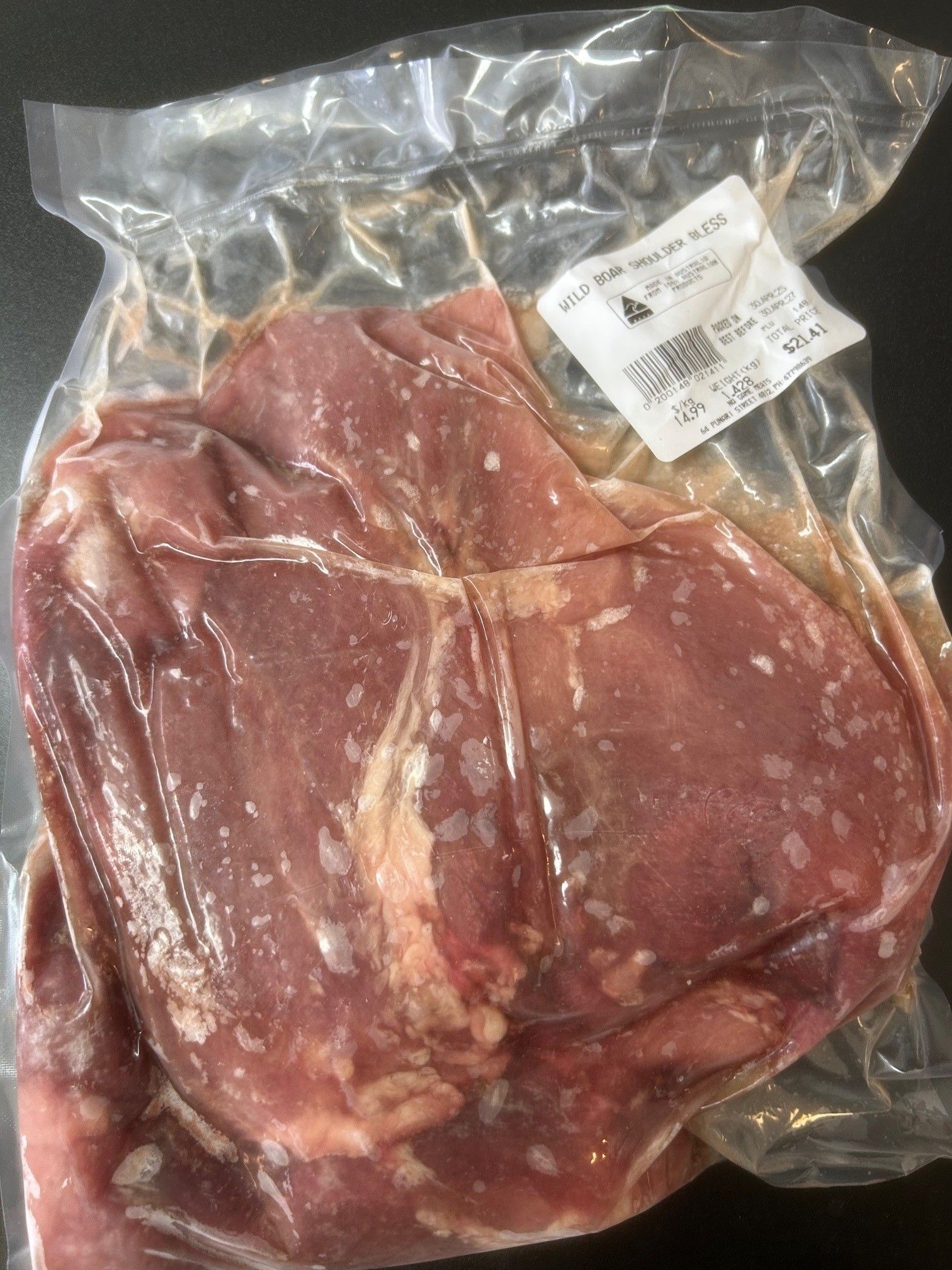Vacuum-sealed package of raw meat. The meat is pinkish-red, with white specks, likely fat. A label is attached — NQ GAME MEAT in Currajong, QLD