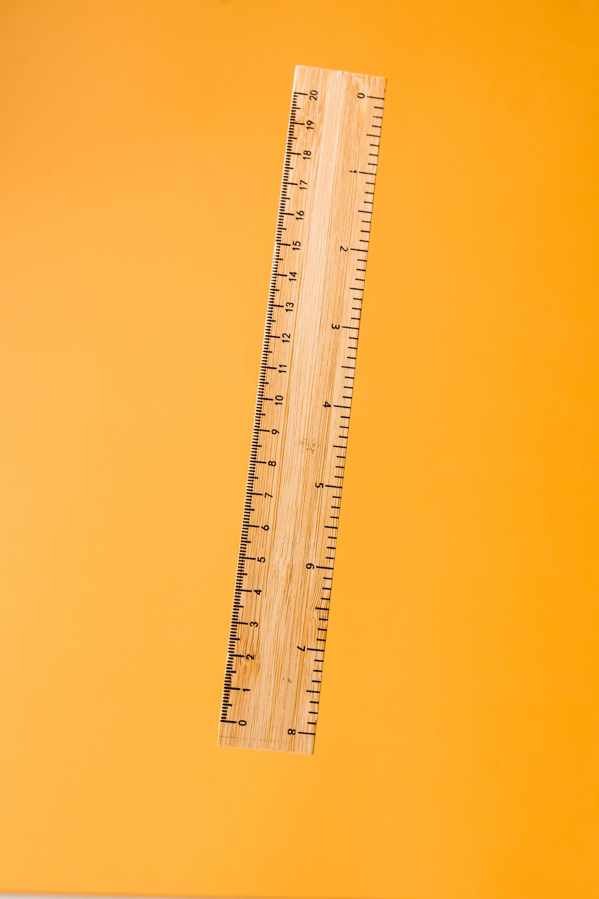 Verticale, transparante liniaal op een feloranje achtergrond.