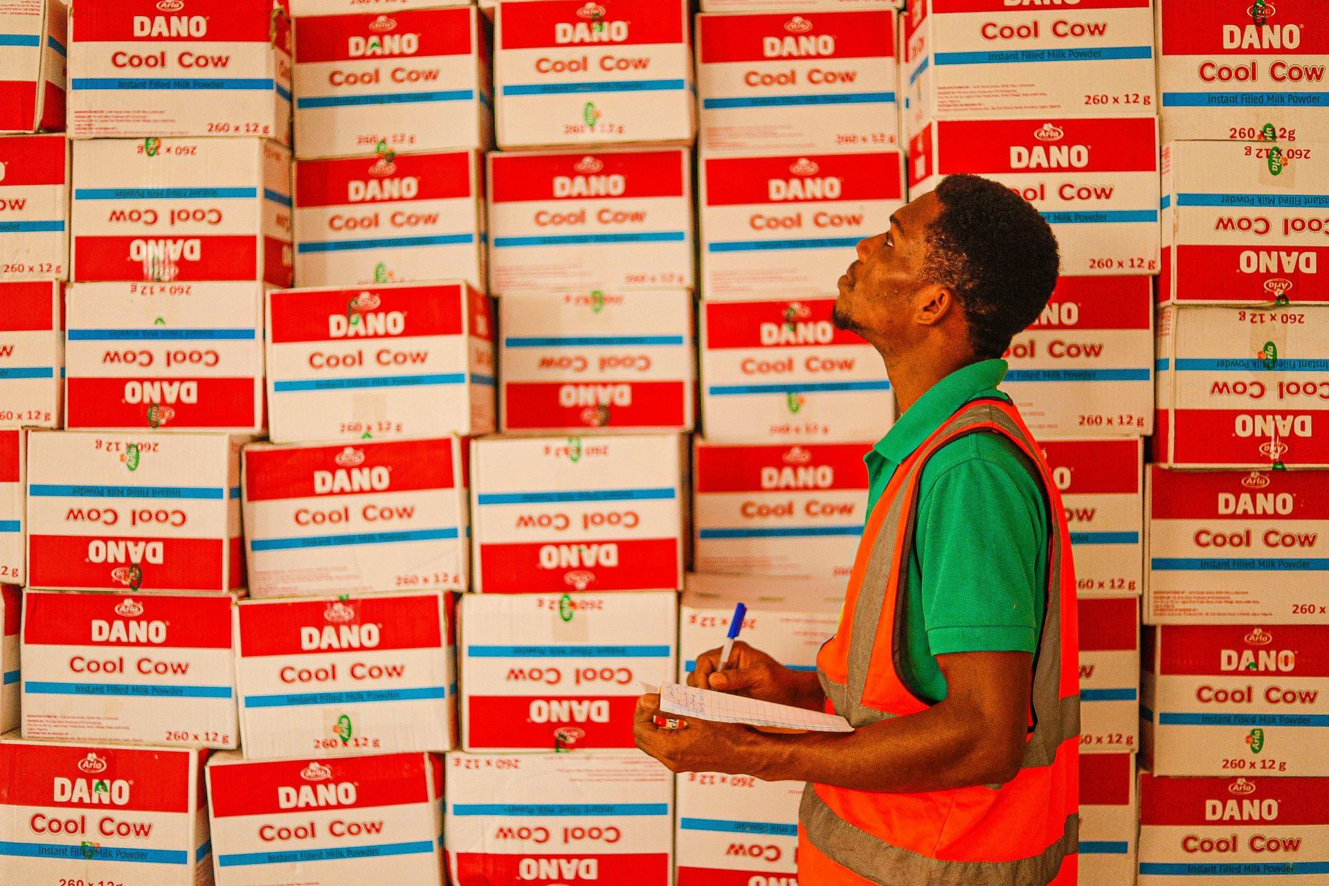 Warehouse employee in Canada doing his job in front of a row of boxes.