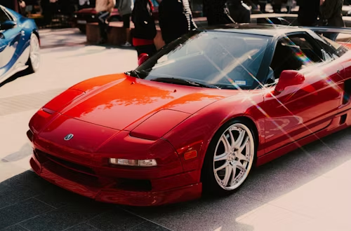 Red Honda NSX sports car, parked, shiny paint, low angle, chrome wheels.