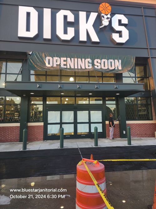 DICK'S Sporting Goods storefront with “OPENING SOON” sign and orange barricade in front