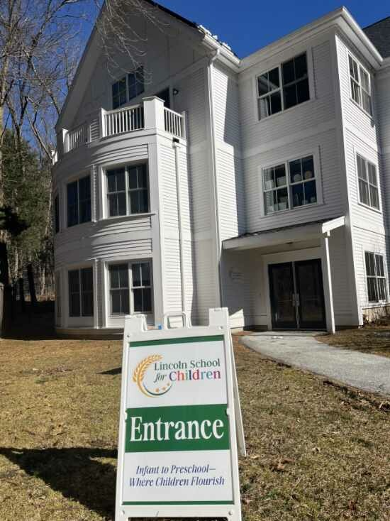 White building: Lincoln School for Children entrance sign on lawn.