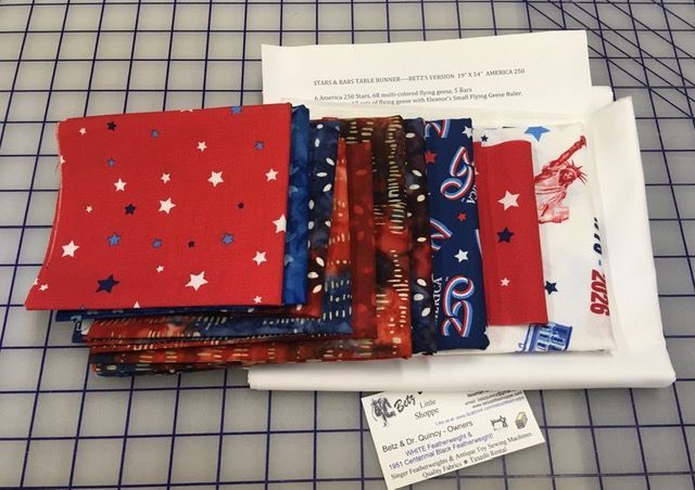 Stack of folded patriotic gift bags and wrapped papers on a wire shelf