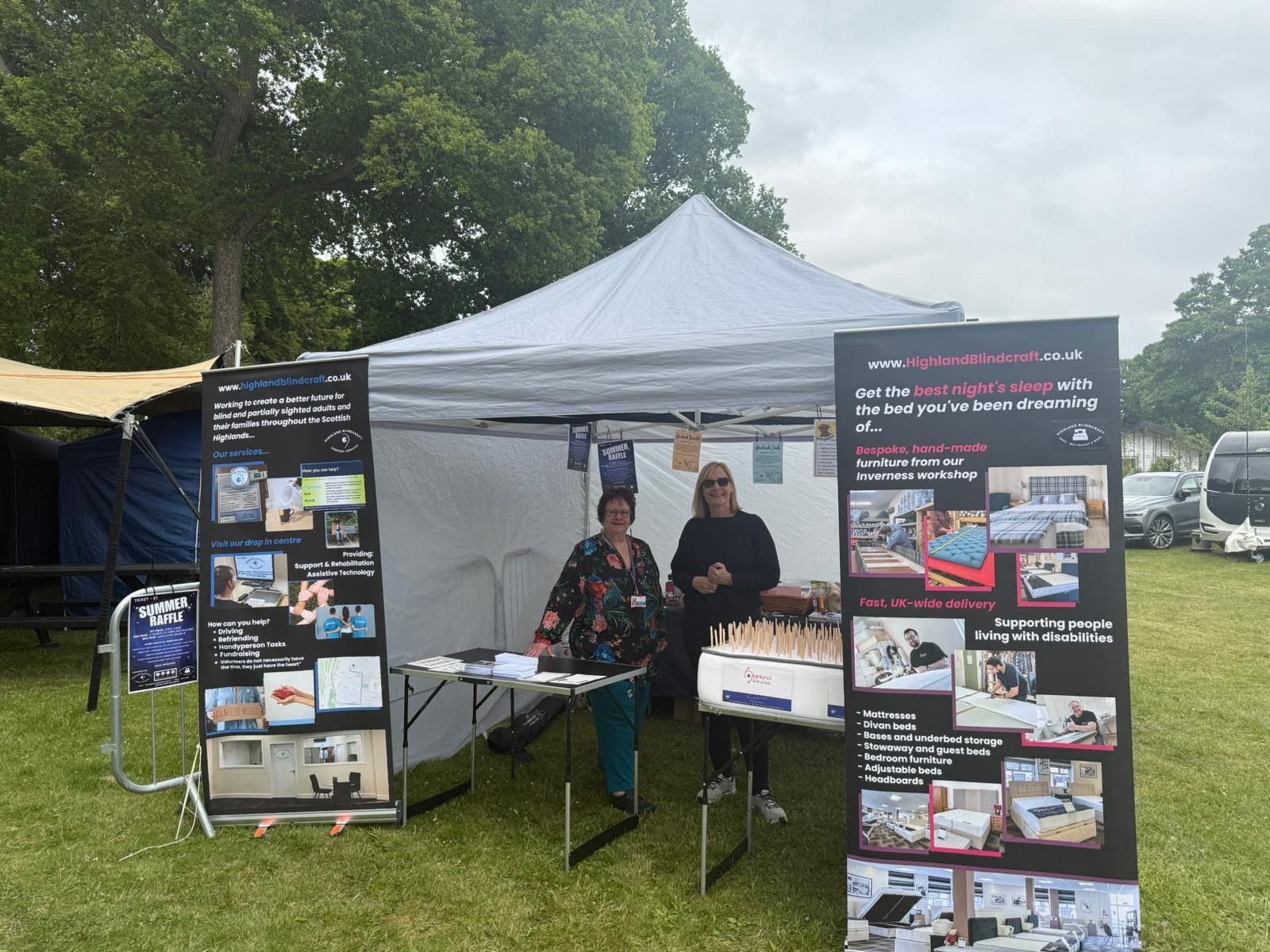 Two people inside of a gazebo advertising Highland BlindCraft beds and sensory services 