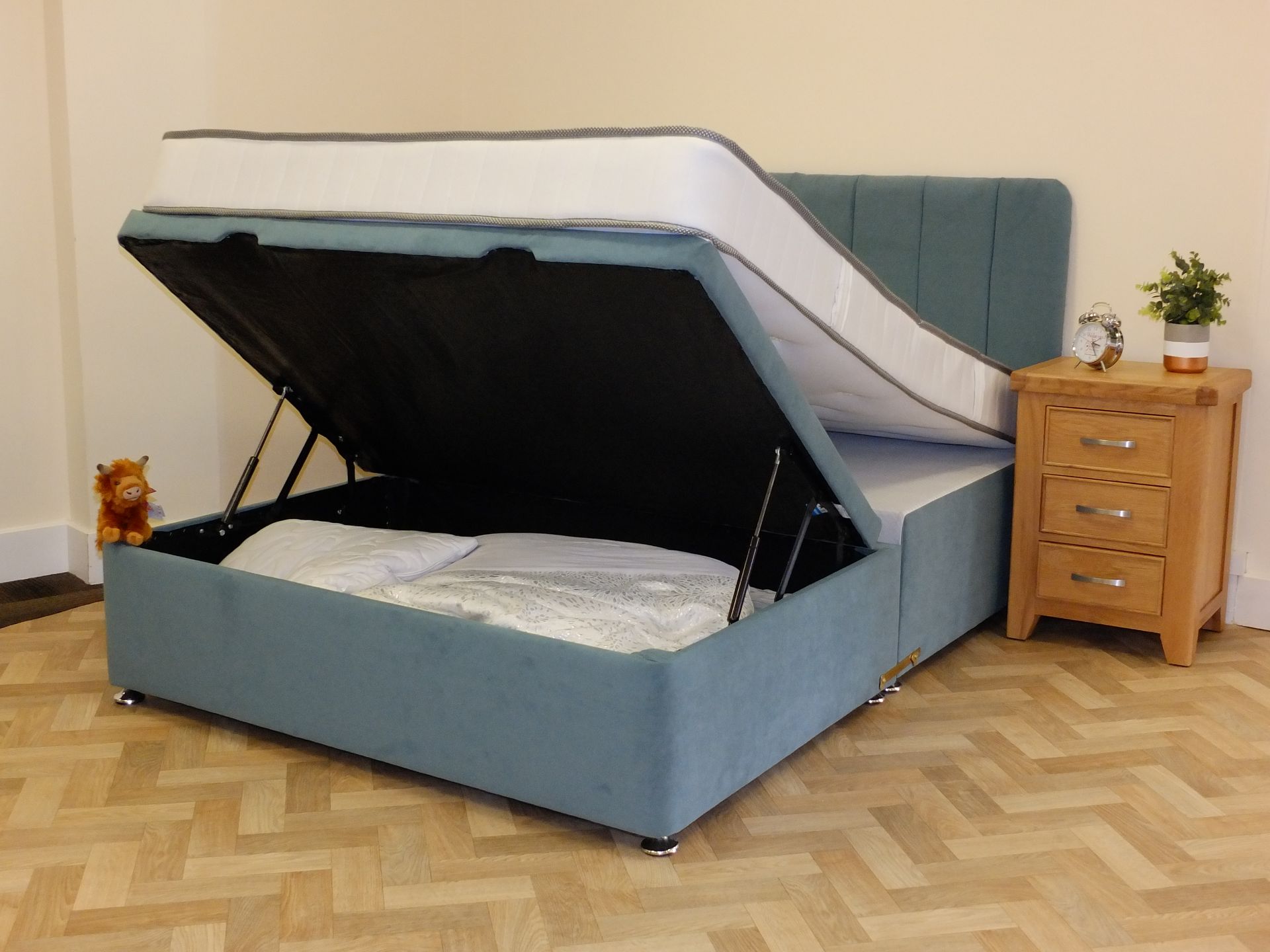 A bed with the lid open and a mattress in it.
