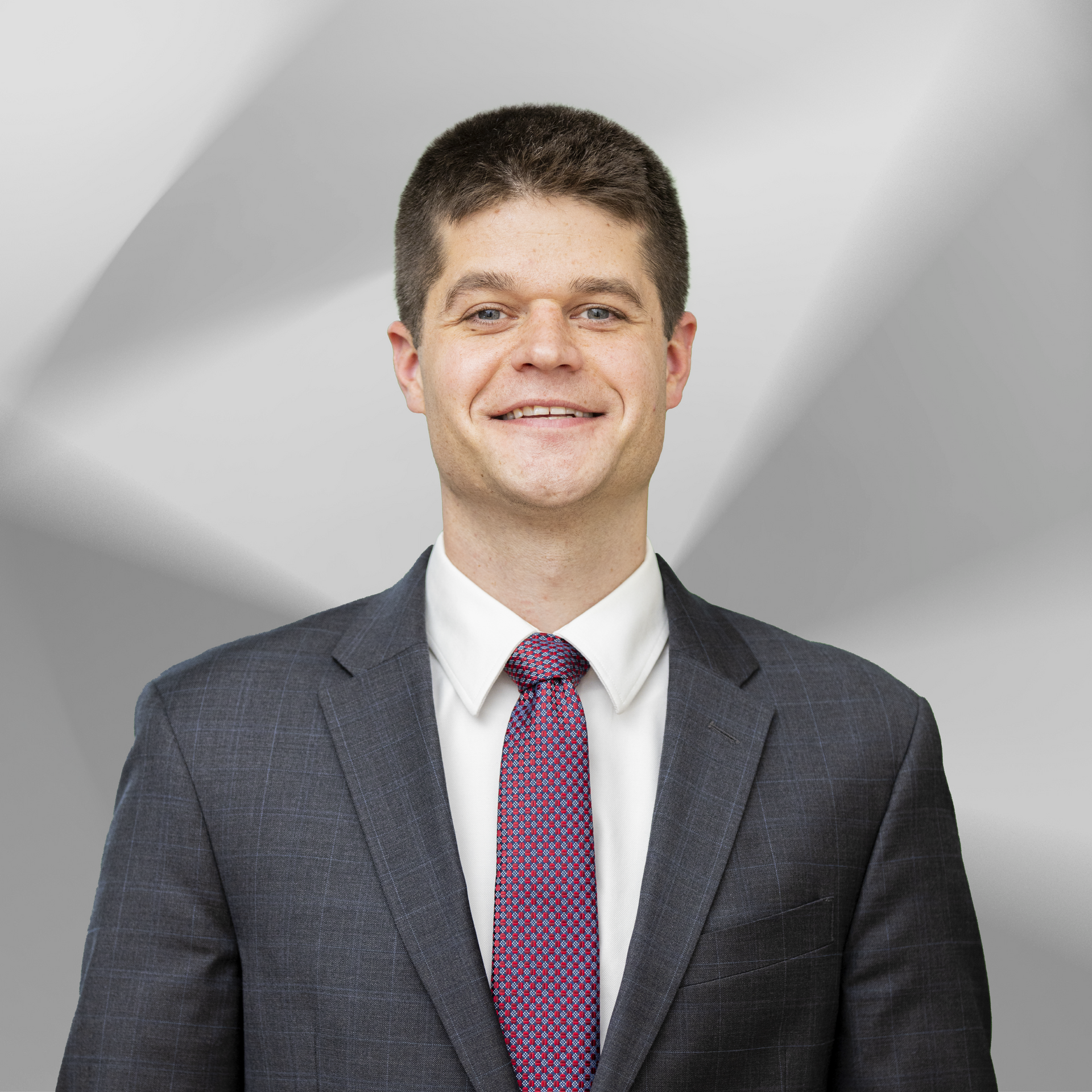 A man in a suit and tie is smiling for the camera