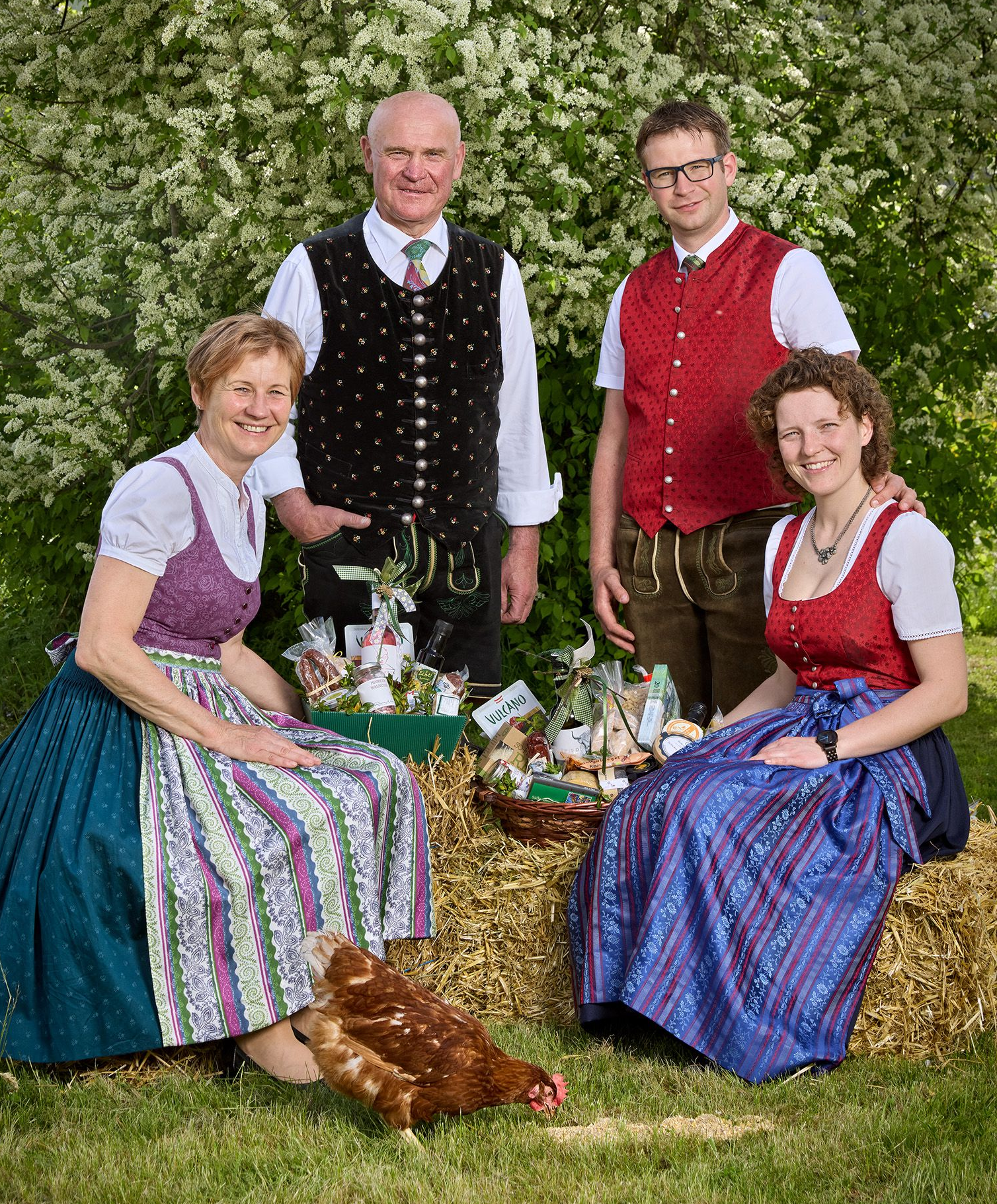 Familienbild in Tracht gekleidet des Hofladen Herk im Garten mit zwei Hühnern