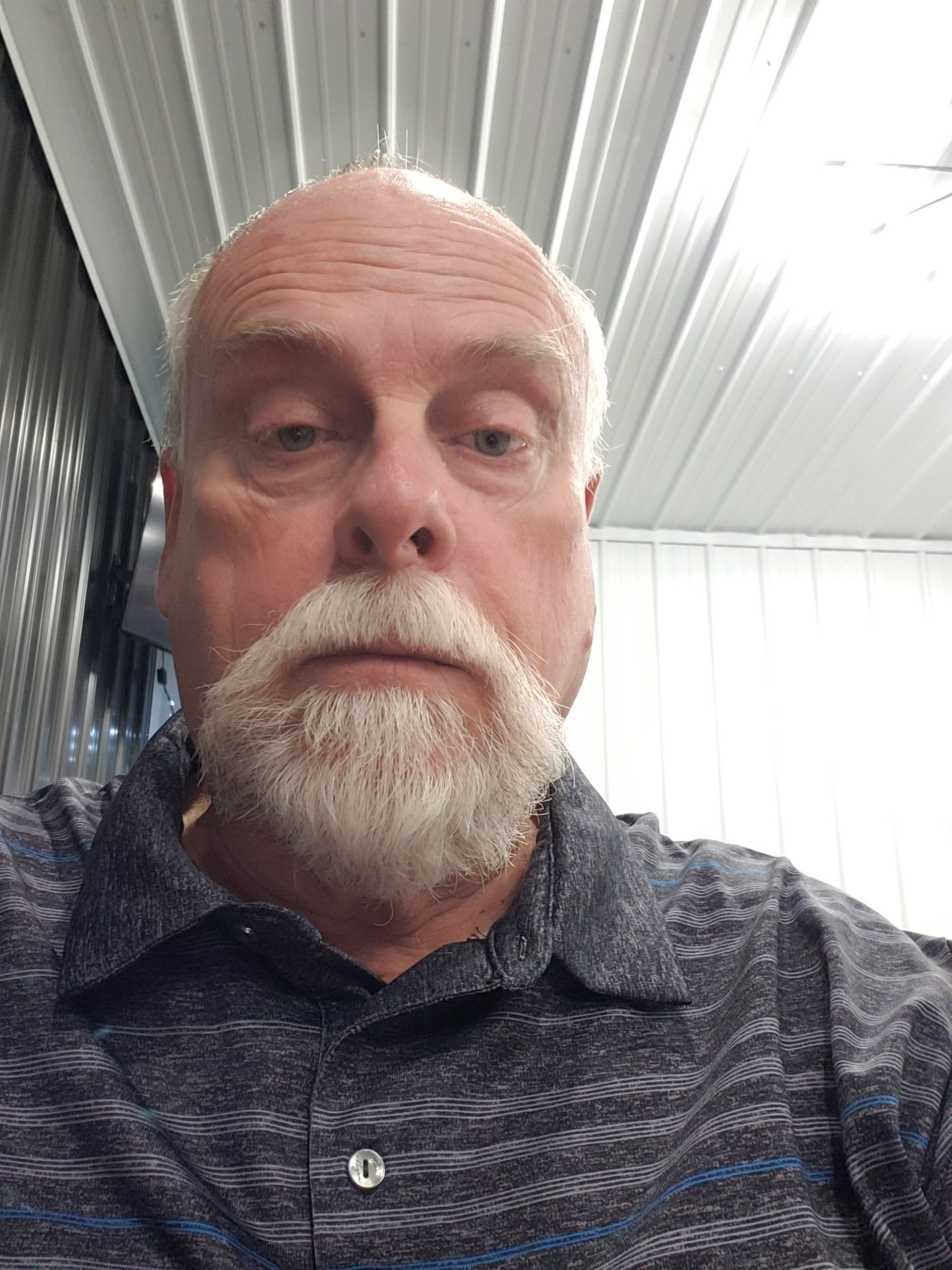 a man with a beard is wearing a striped shirt