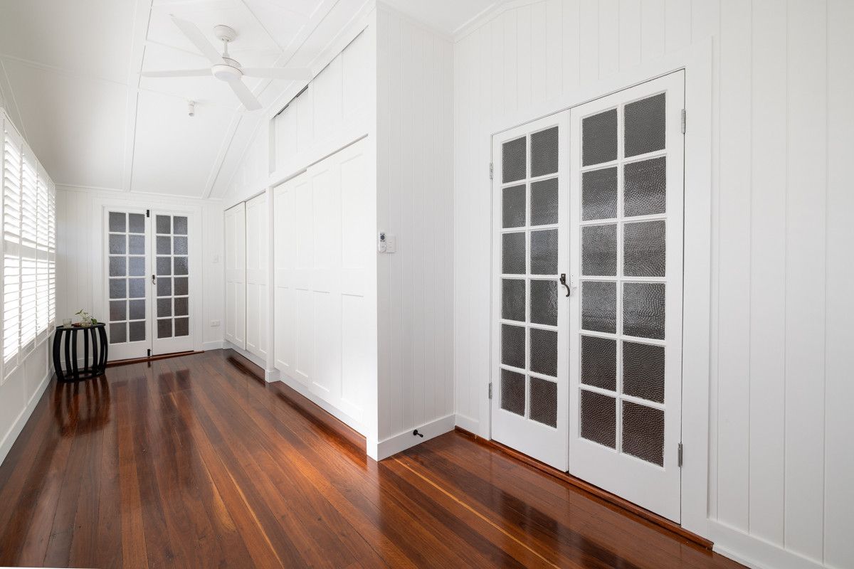 An Empty Room With Hardwood Floors, White Walls And French Doors — Ironbark Built Townsville in Currajong, QLD