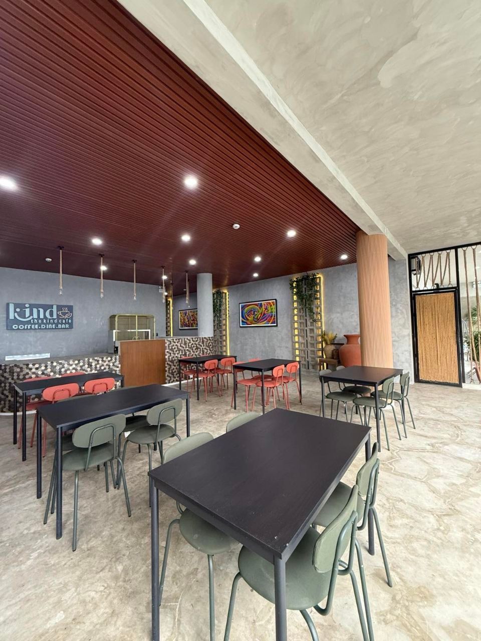 A restaurant with tables and chairs and a sign that says kind