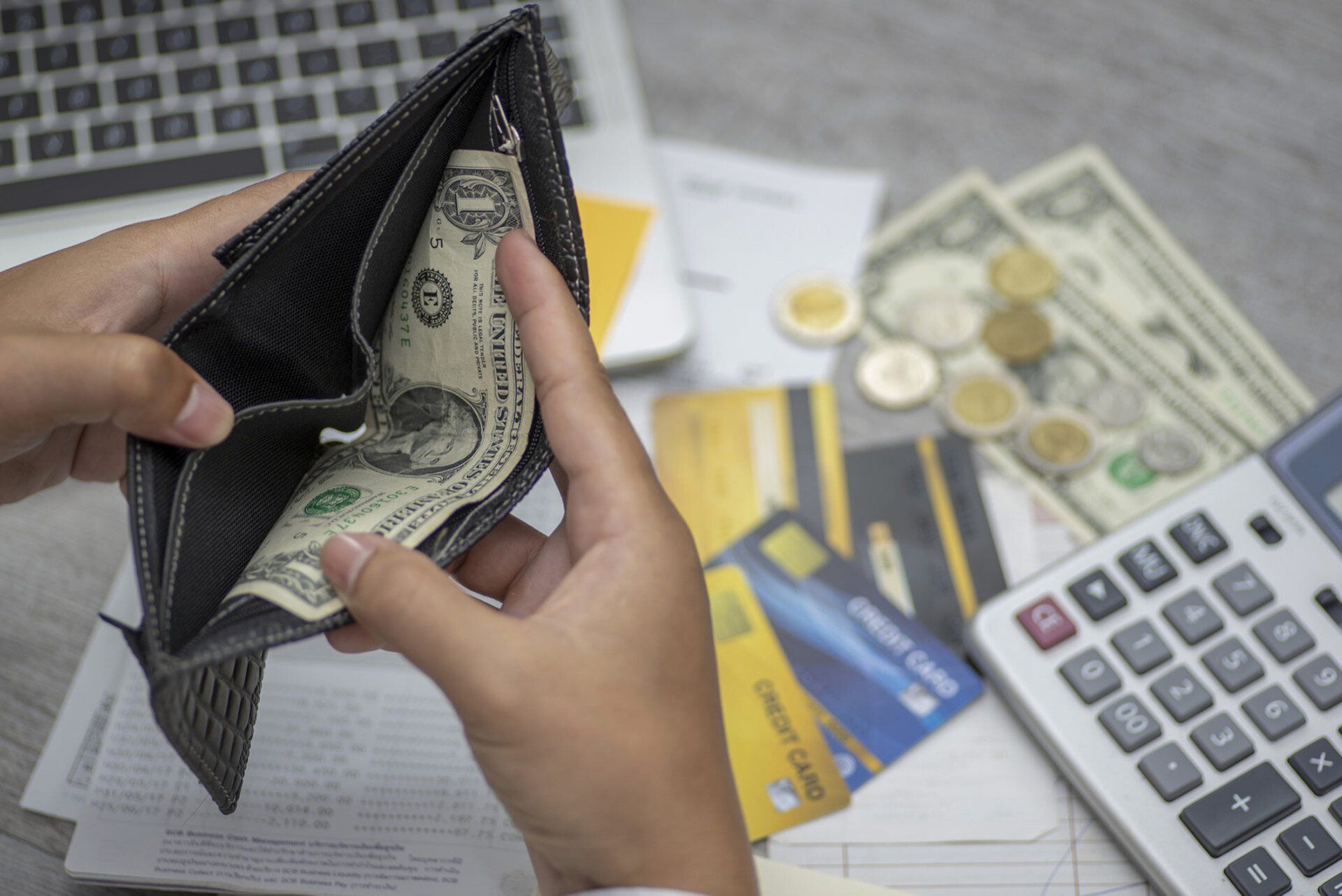 Hands holding wallet with money inside — Waukegan, IL — Aapril Tax Service