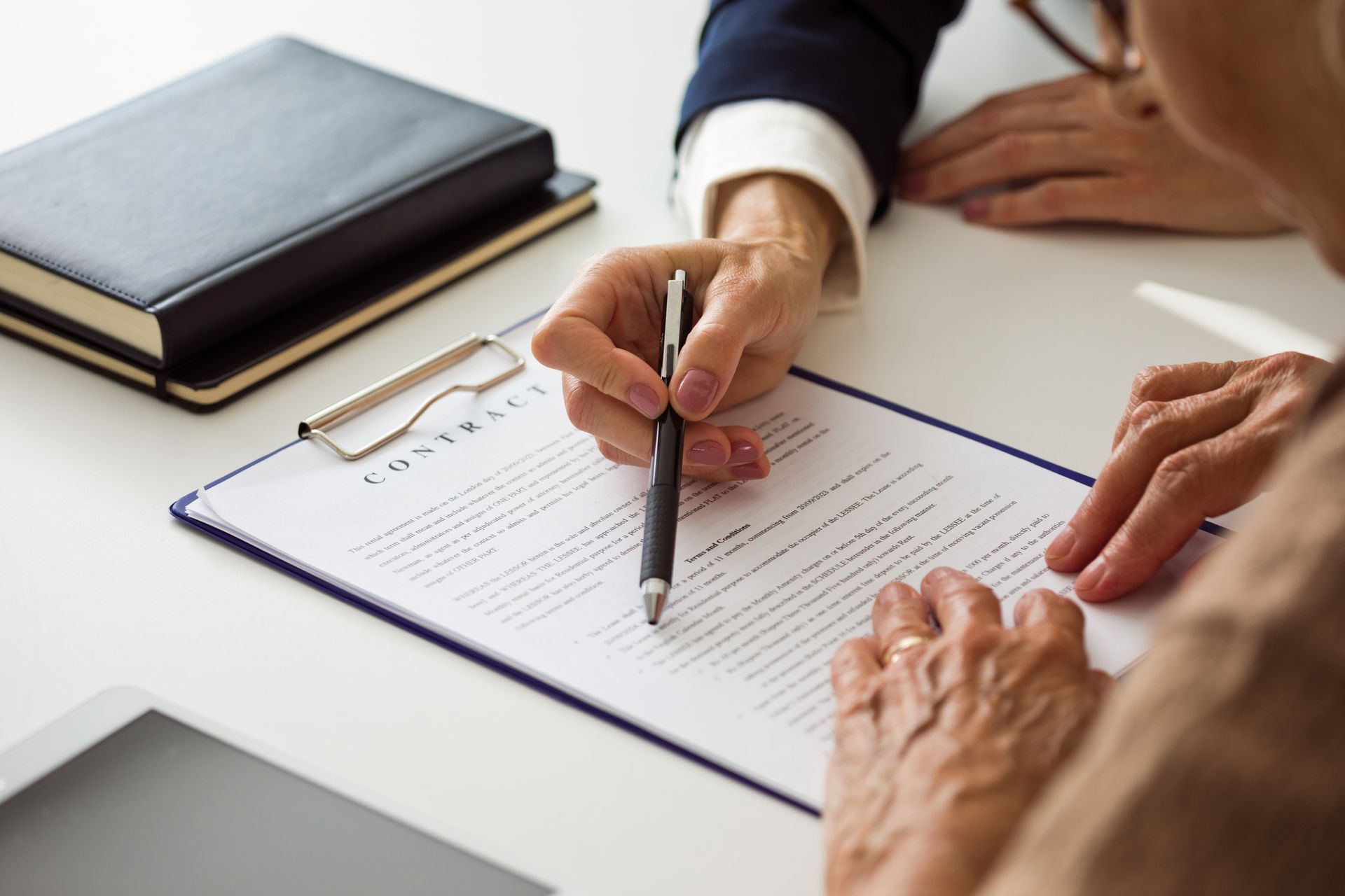 Senior woman discussing contract with lawyer.