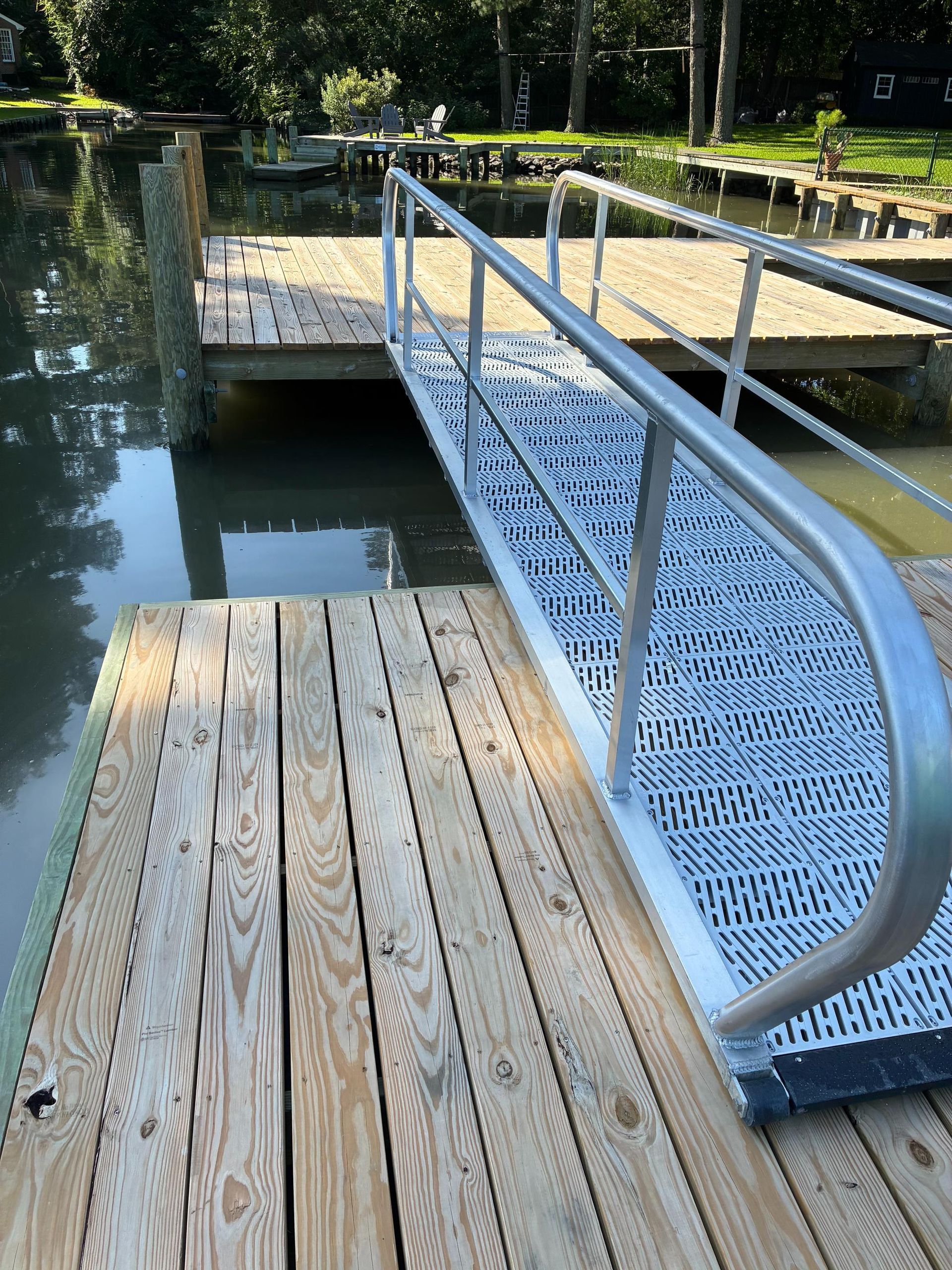 Dock with a ramp and handrails over water.