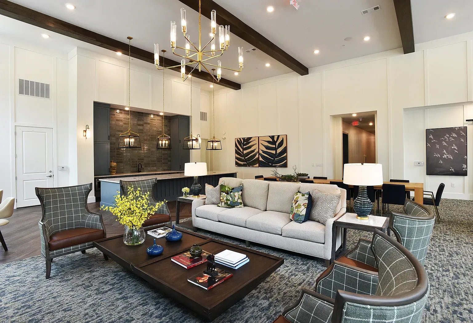 Bright modern dining room with tables, chairs, large windows, and a high coffered ceiling.