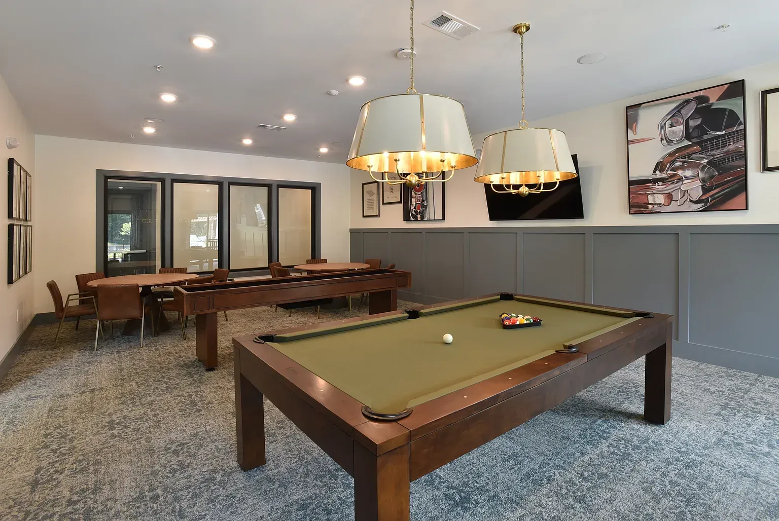 Game room with a pool table, TV, seating area, and large windows