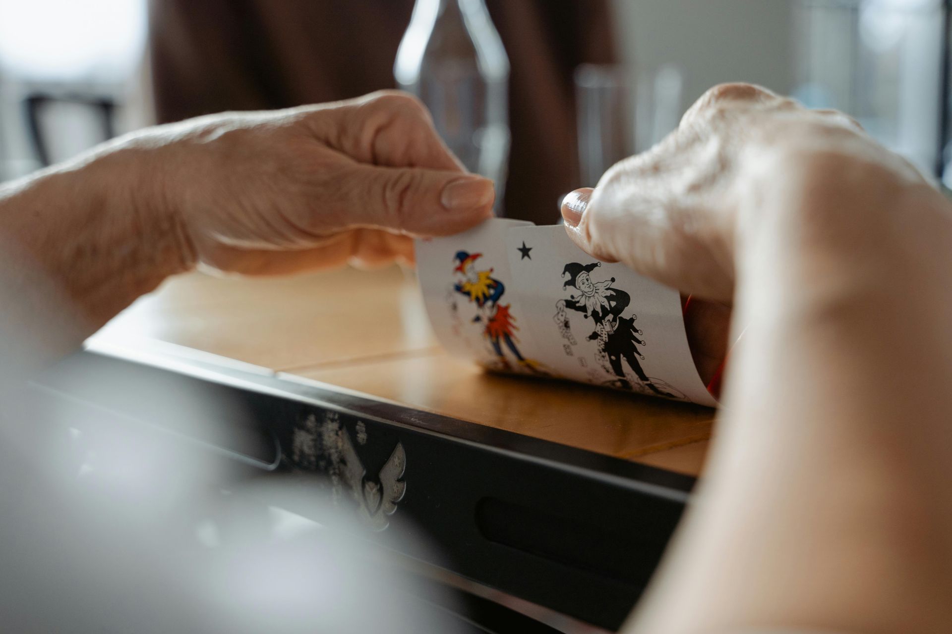 Hands rolling a white sushi mat with colorful patterns on a counter