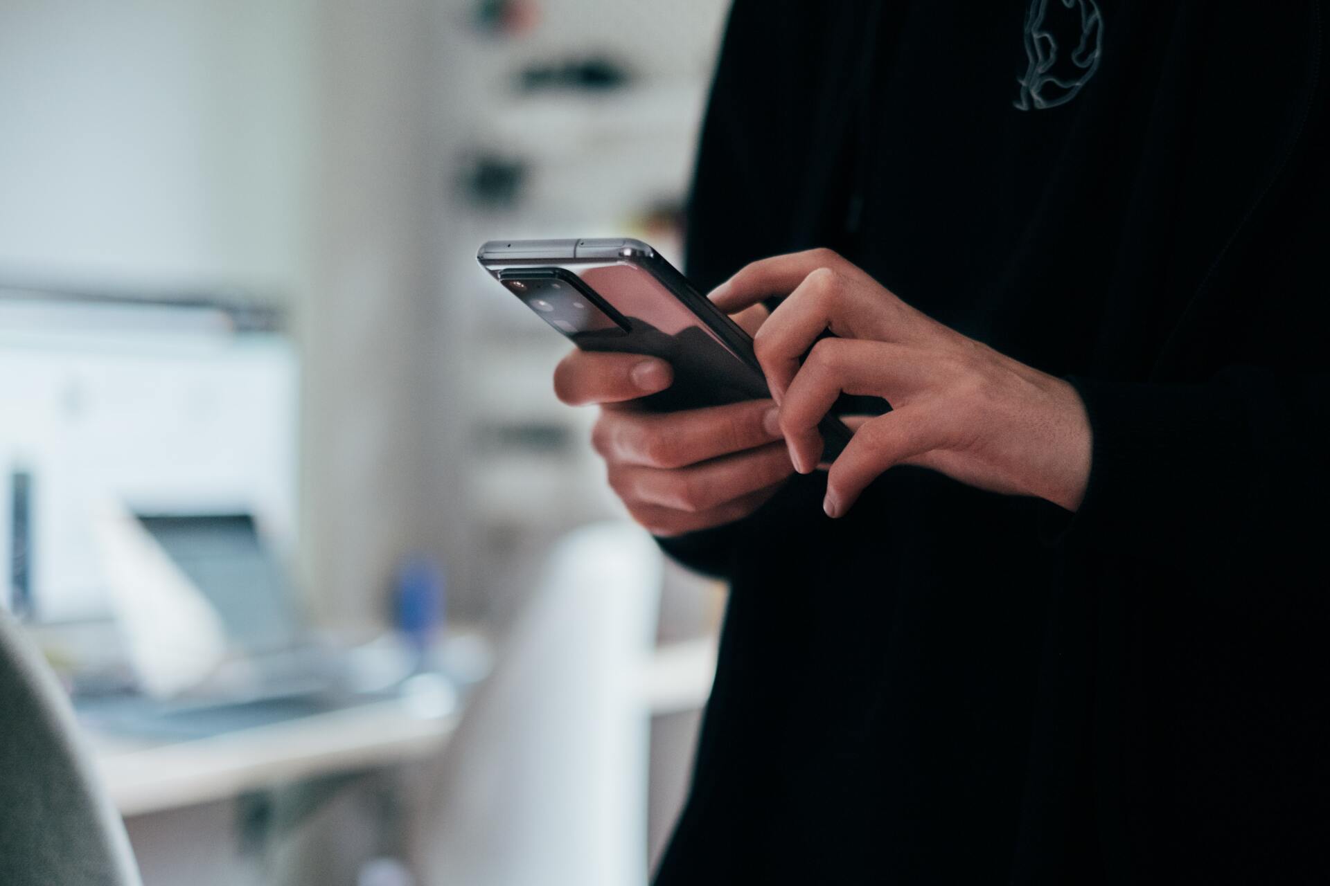 hands holding a phone dialing