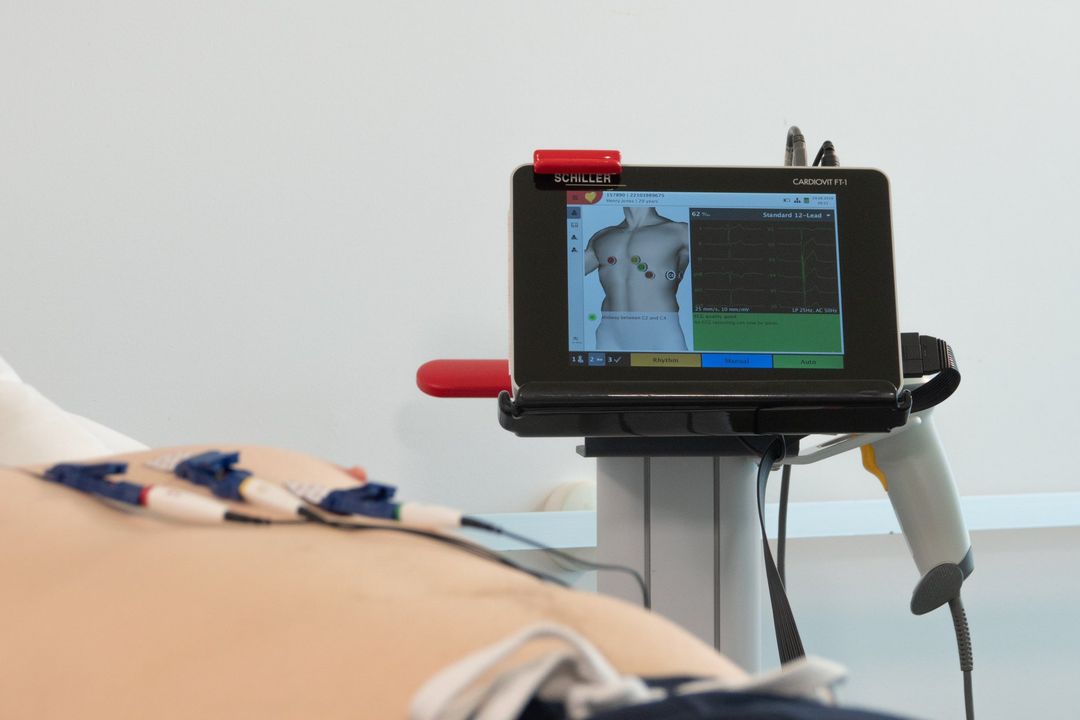 A person is laying on a bed with a device on their back.