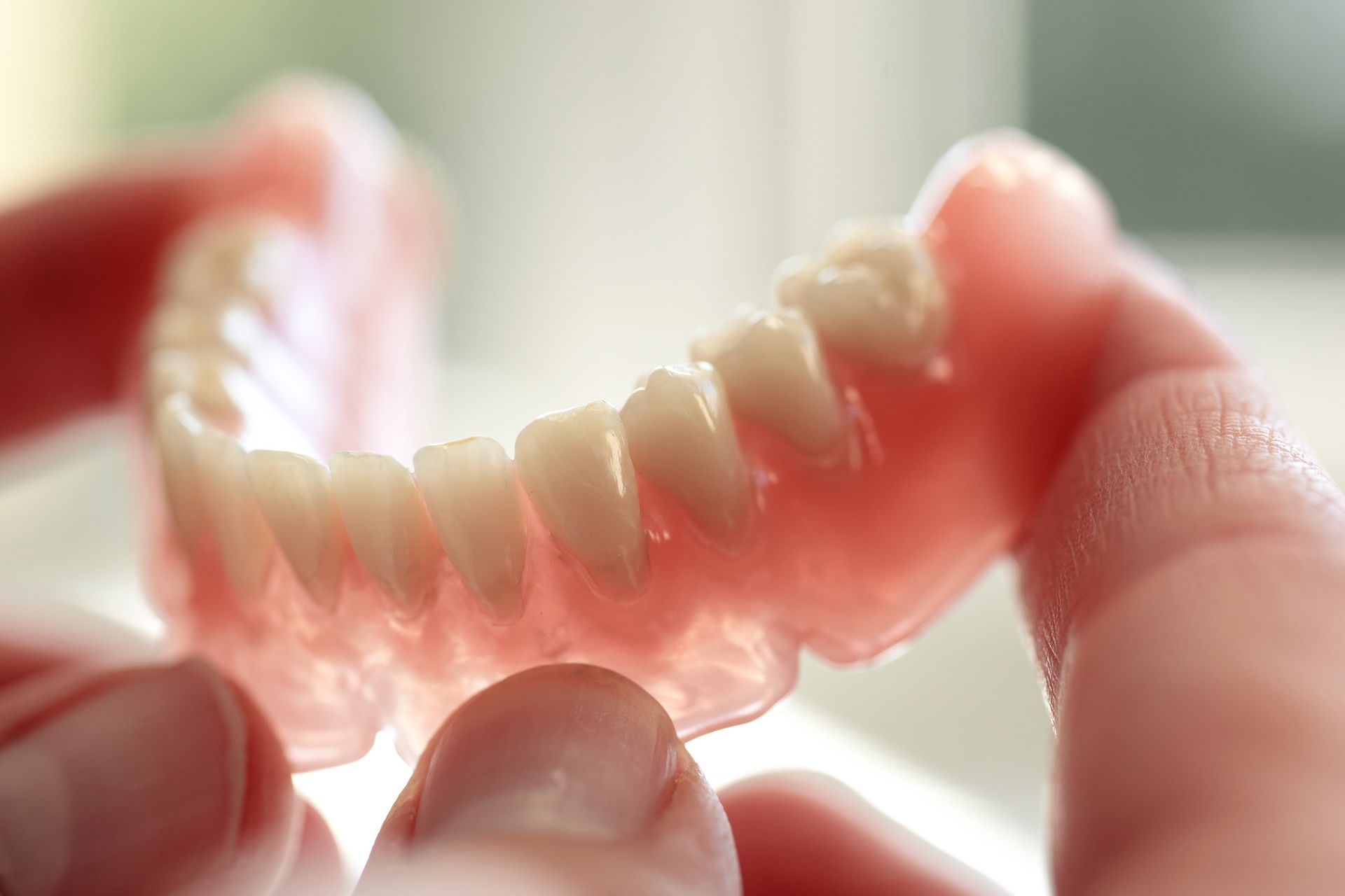 Hand Holding A Denture — North Geelong, VIC — Shyne Dental & Denture Clinic Hand Holding A Denture — North Geelong, VIC — Shyne Dental & Denture Clinic