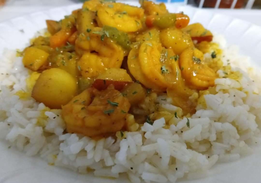 A close up of a plate of food with shrimp and rice