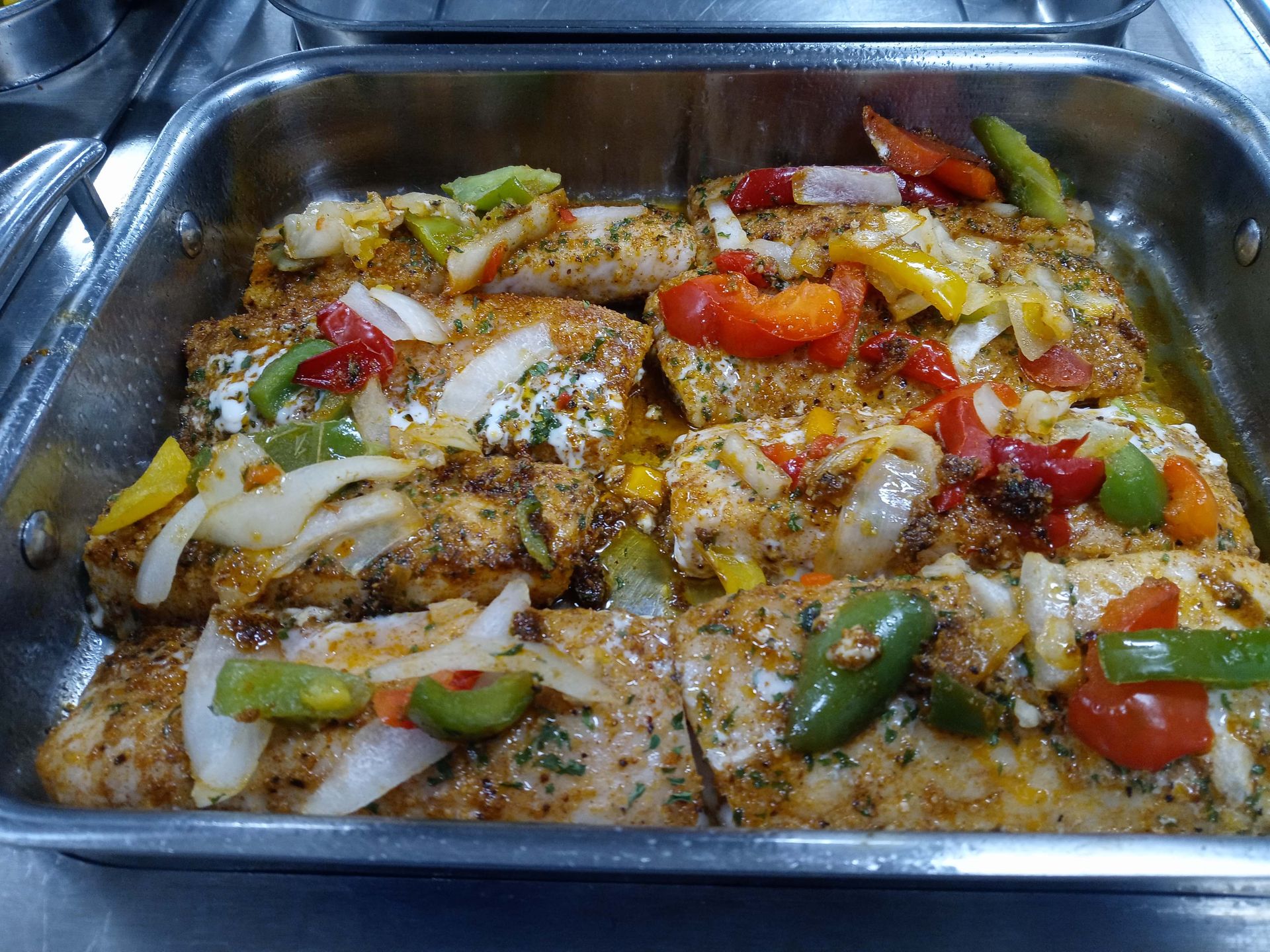 A pan filled with chicken and vegetables on a stove.