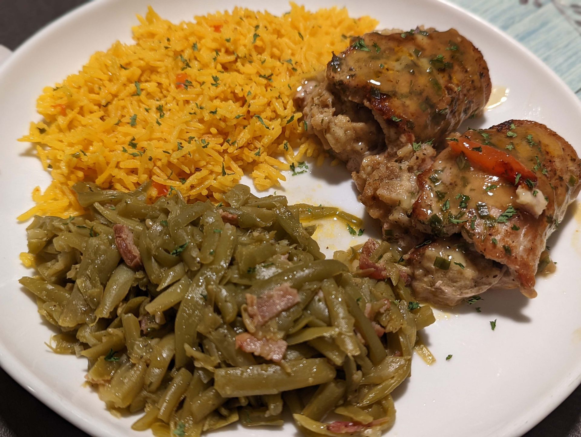 A white plate topped with green beans , rice and meat.