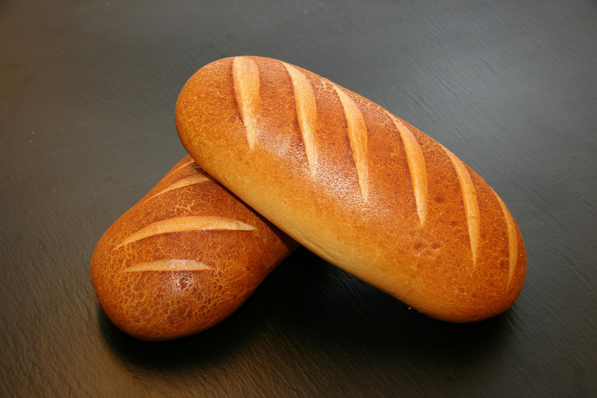 Two loaves of bread are stacked on top of each other on a table.