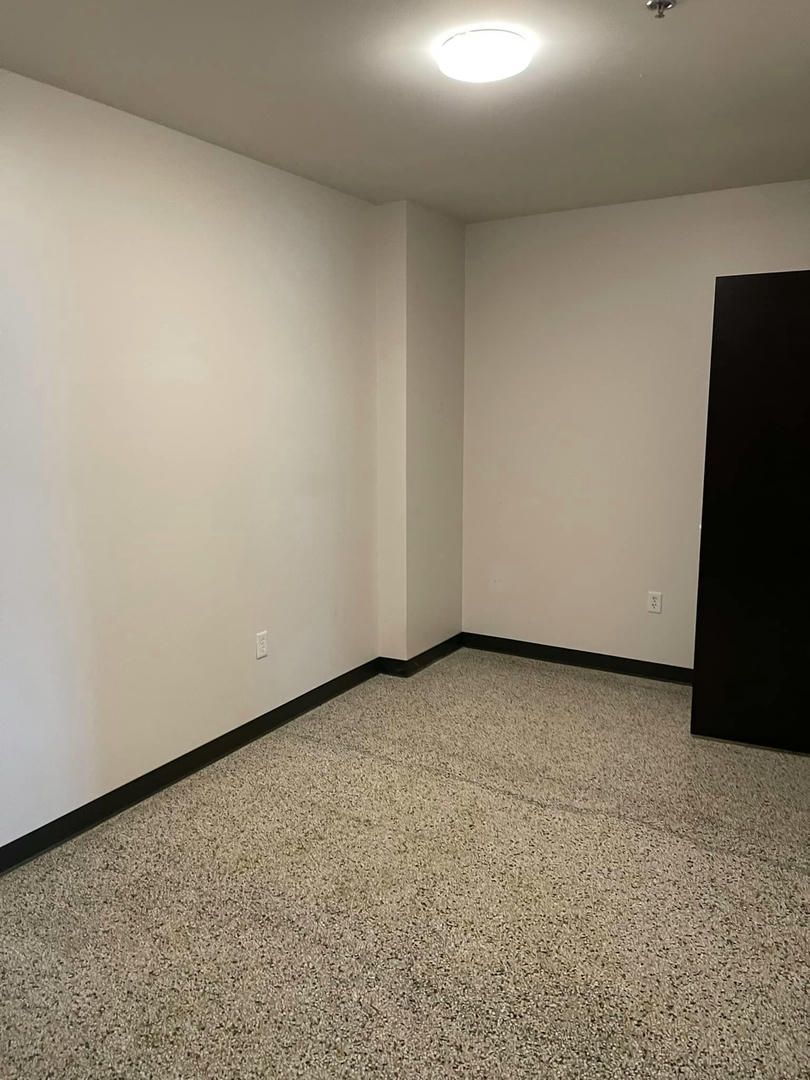 An empty room with a tiled floor and white walls.