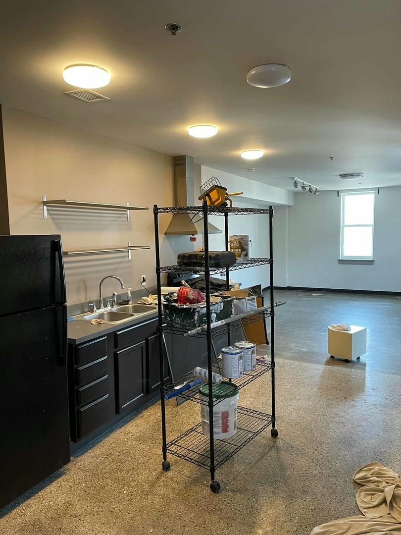 A kitchen with a refrigerator , sink , and shelves.