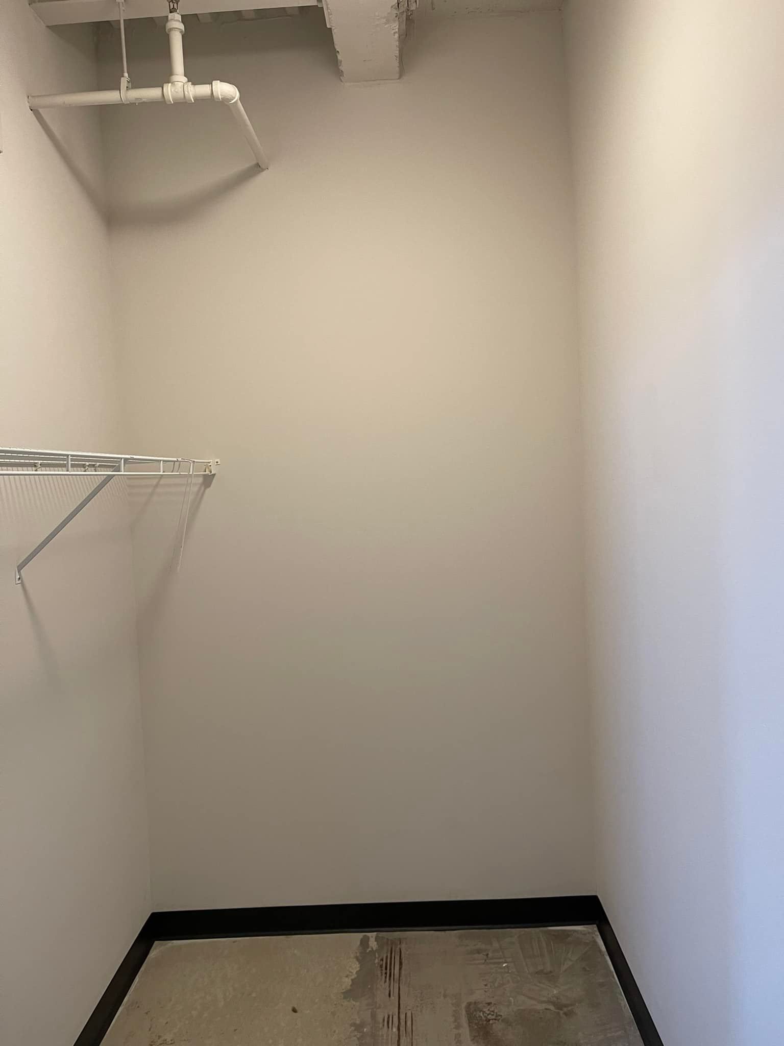 An empty walk in closet with a shelf and shelves.