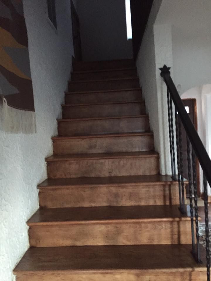 A Set Of Wooden Stairs With A Black Railing